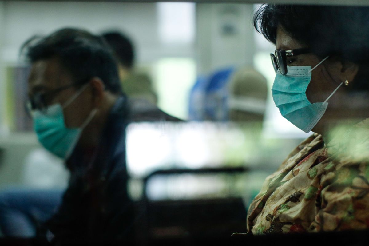 Calon penumpang kereta api mengenakan masker di Stasiun Gambir, Jakarta, Jumat (31/1/2020). PT KAI Daop 1 Jakarta membagikan masker gratis pada calon penumpang dalam rangka mengantisipasi penyebaran virus corona.
