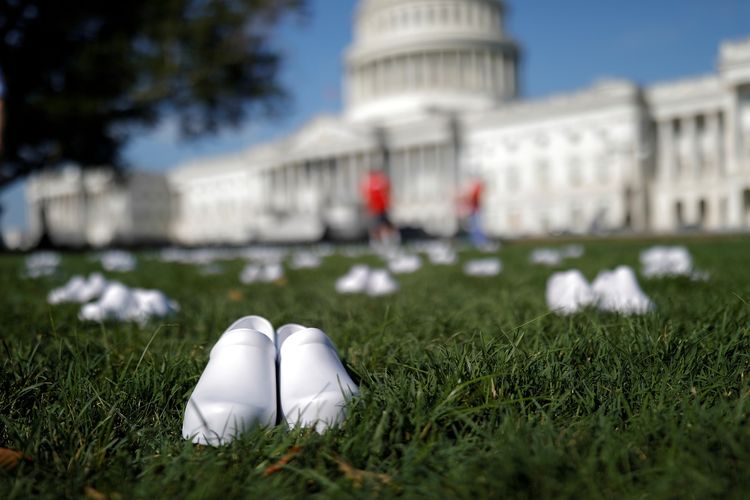 Sepatu putih dipajang dalam aksi yang dilakukan Perawat Teregistrasi dan Uni Perawat Nasional (NNU) untuk mengenang rekan mereka yang gugur karena Covid-19 di Gedung Capitol, Washington DC, Amerika Serikat (AS) pada 21 Juli 2020.