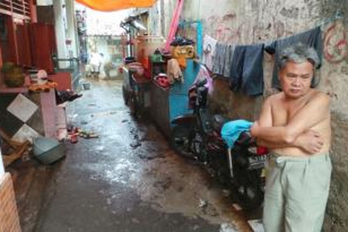 Komarudin (55) tak bisa berbuat apa-apa saat banjir melanda permukimannya di Kampung Pulo, Jatinegara, Jakarta Timur, Kamis (8/8/2013). Meski tak berkumpul bersama keluarga besar, ia malah mendapat makna Lebaran yakni berkumpul bersama keluarga intinya.