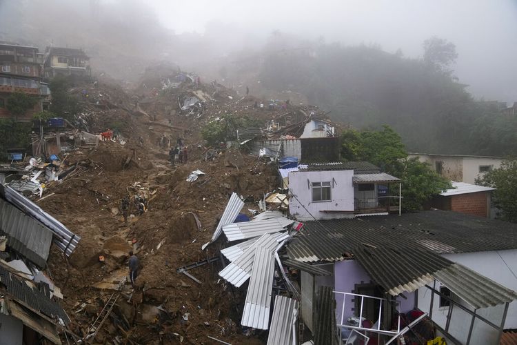 Petugas penyelamat dan penduduk mencari korban di daerah yang rusak akibat tanah longsor di Petropolis, Brasil, Rabu, 16 Februari 2022. 