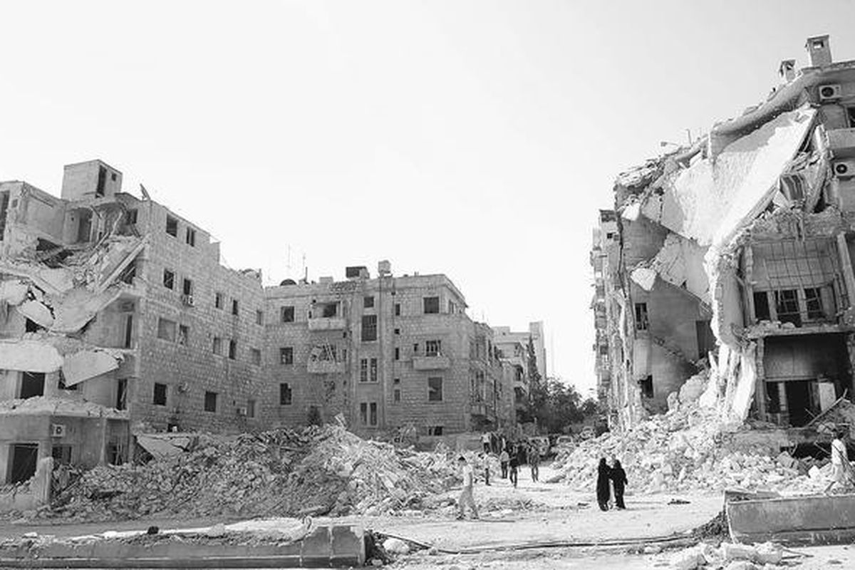 Warga  Aleppo berjalan di dekat reruntuhan bangunan di dekat Rumah Sakit Al-Hayat di Aleppo, Senin (10/9). Utusan Khusus Perserikatan Bangsa-Bangsa dan Liga Arab untuk Suriah, Lakhdar Brahimi, mengakui menghadapi tugas yang sangat sulit untuk mengakhiri konflik bersenjata yang berjalan hampir 18 bulan itu. 
