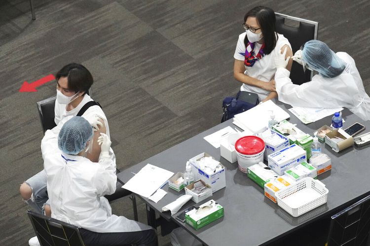 Petugas kesehatan memberikan dosis vaksin AstraZeneca COVID-19 kepada orang-orang di pusat perbelanjaan Paragon di Bangkok, Thailand, Senin, 7 Juni 2021.