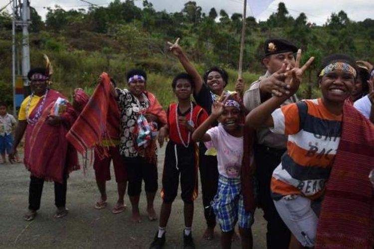 Warga Papua mengibarkan Bendera Merah Putih saat menyambut kedatangan Presiden Joko Widodo dan rombongan di Jayapura, Papua, 9 Mei 2015.