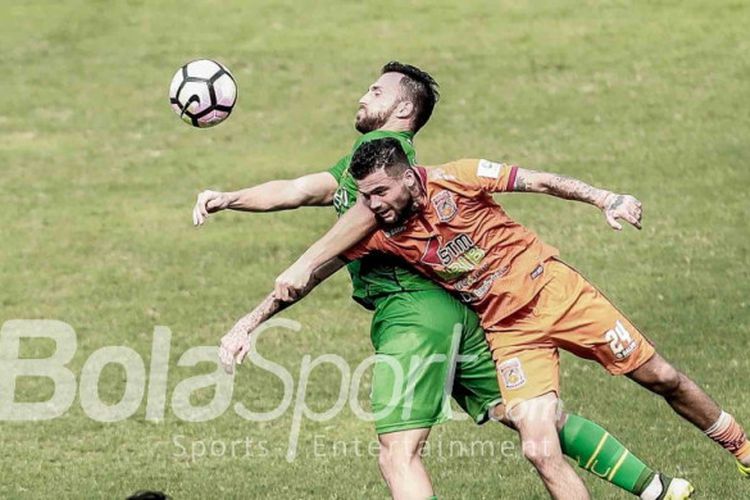 Penyerang Bhayangkara FC, Ilija Spasojevic, berduel dengan bek Borneo FC, Diego Michiels, pada lanjutan laga Liga 1, 20 September 2017.