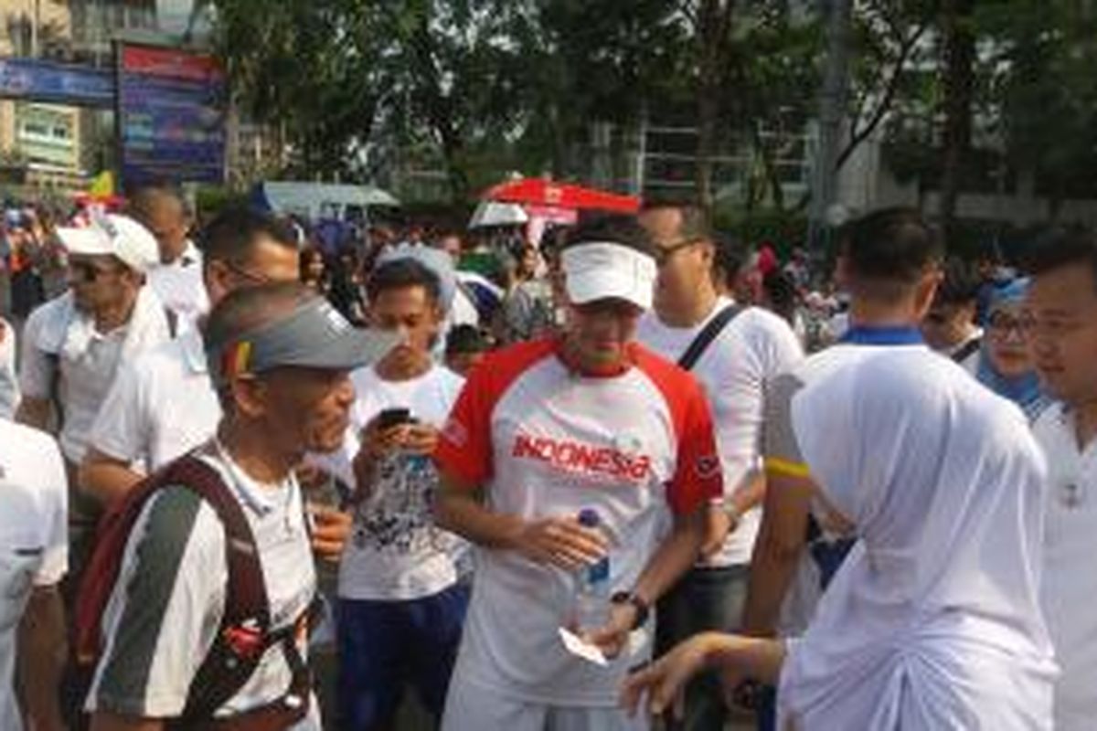 Sandiaga Uno (mengenakan kaos bertuliskan Indonesia) saat hadir dalam kegiatan car free day di Bundaran HI, Jakarta, Minggu (11/10/2015). Ia hadir menyapa pendukungnya yang sedang melakukan Aksi Santun, yakni aksi mengajak warga tersenyum dan tidak bersikap kasar.