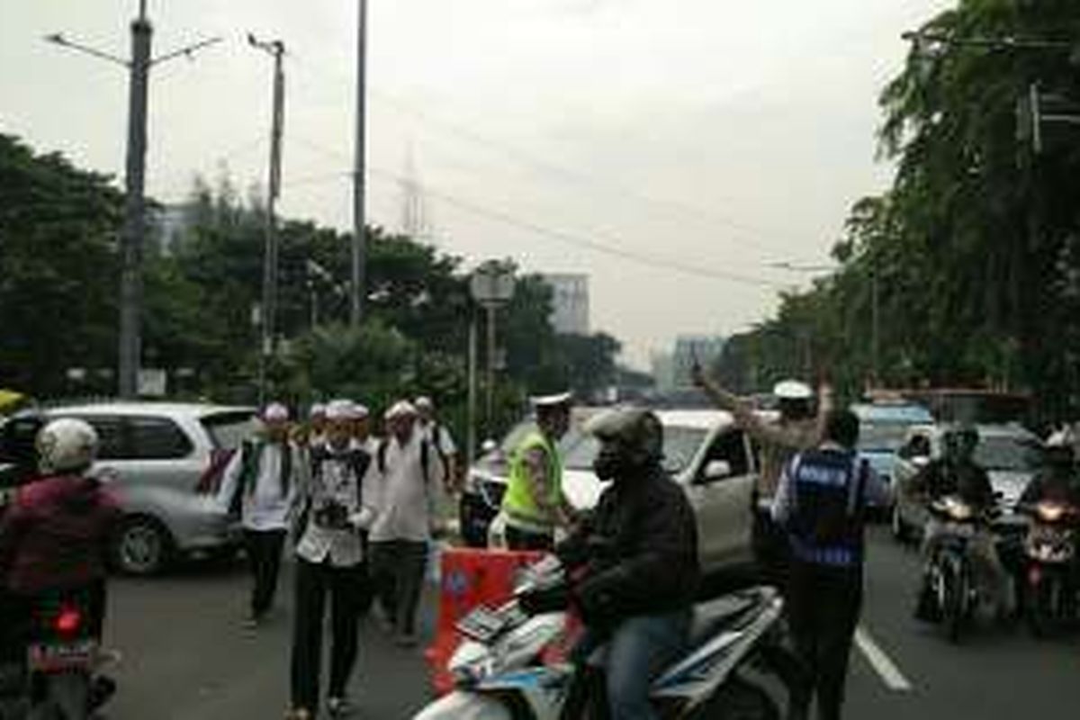 Polisi dan petugas Dishub DKI Jakarta mengatur arus lalu lintas di Jalan Medan Merdeka Timur, Jakarta Pusat, Jumat (4/11/2016). Kendaraan dari arah Tugu Tani kembali dialihkan menuju jalan tersebut.