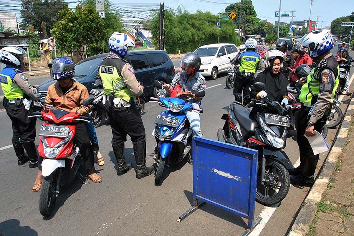 Sejumlah anggota Satlantas Polres Bogor melakukan operasi Zebra Lodaya 2019 di jalan raya Jakarta-Bogor, Cibinong, Kabupaten Bogor, Jawa Barat, Rabu (23/10/2019). Dalam operasi Zebra Lodaya 2019 yang bertujuan untuk meningkatkan kesadaran dan kepatuhan masyarakat dalam berlalu lintas serta mengurangi angka kecelakaan di jalan raya tersebut, Satlantas Polres Bogor telah menilang sebanyak 340 pelanggar yang sebagian besar pengendara motor yang tidak memakai helm, surat tidak lengkap dan kelebihan muatan.