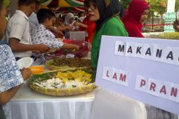 Seorang petugas Musium Aceh sedang menjelaskan tentang makanan tradisional yang menjadi makanan bekal perang di Aceh kepada pengunjung pameran peringatan 100th Musium Aceh, khususnya kepada pelajar. *****K12-11