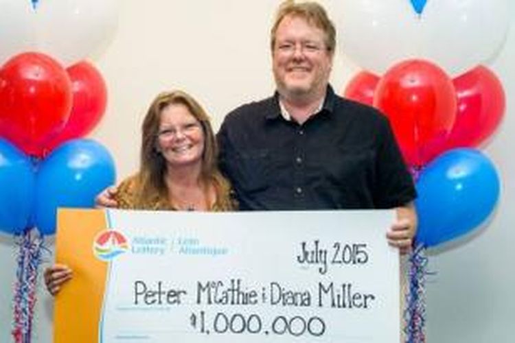 Peter McCathie dan Diana Miller memamerkan cek 1 juta dolar yang menjadi haknya setelah memenangkan sebuah lotere di Kanada.