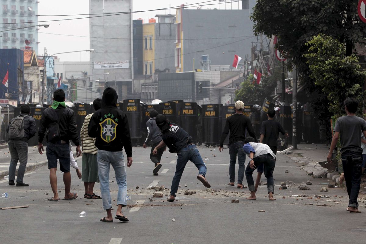 Bentrokan antara warga dan aparat saat pembongkaran rumah di Kampung Pulo, Jakarta Timur, Kamis (20/8/2015). Pembongkaran rumah di bantaran kali ini dilakukan untuk normalisasi Kali Ciliwung. KOMPAS IMAGES/KRISTIANTO PURNOMO