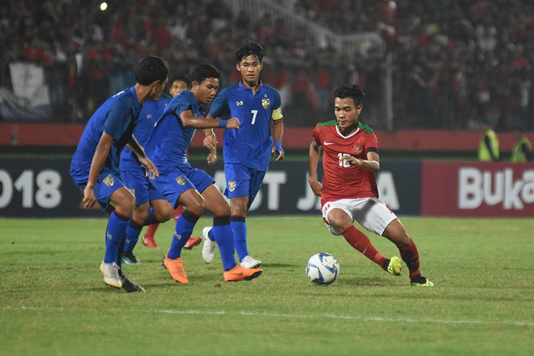 Pesepak bola Indonesia Brylian Neglehta Dwiki Aldama (kanan) berusaha melewati hadangan pesepak bola Thailand dalam pertandingan final Piala AFF U-16 di Stadion Gelora Delta Sidoarjo, Jawa Timur, Sabtu (11/8/2018). Timnas U-16 Indonesia keluar sebagai juara Piala AFF U-16 2018 setelah mengalahkan Thailand lewat babak adu penalti dengan skor 4-3