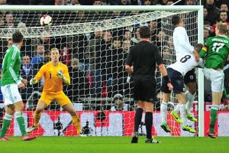 Kapten Jerman, Per Mertesacker (2 dari kanan) menyundul bola yang menghasilkan gol dalam uji coba melawan Inggris di Wembley, Selasa (19/11/2013).