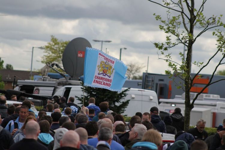 Para suporter Manchester City membawa bendera Juara Inggris saat Man City memastikan gelar juara Liga Inggris 2013-2014 di Stadion Etihad, Manchester, pada 11 Mei 2014.