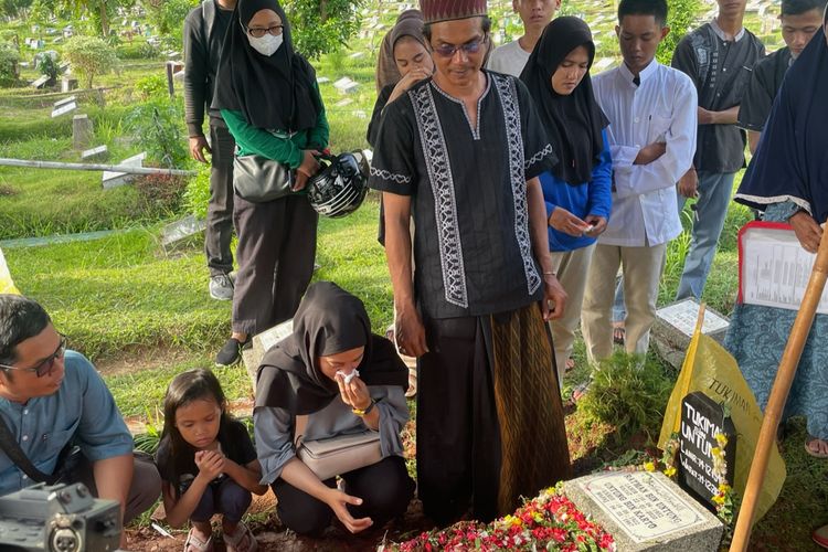 Anak-anak mendiang Otis Pamutih mengantarkan ke liang lahad di Tempat Pemakaman Umum (TPU) Cipinang Asem kawasan Kebon Pala, Jakarta Timur, Rabu (14/12/2022).  