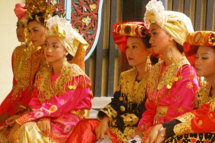 Para perempuan sedang mengenakan kostum tradisional Minang