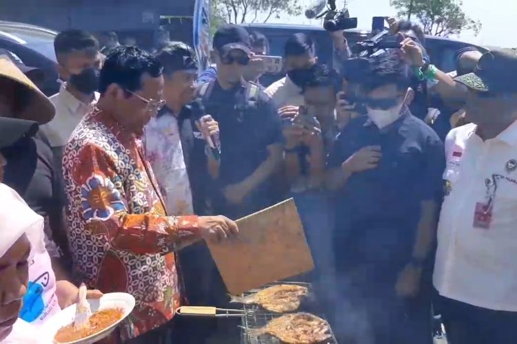 Menteri Koordinator Bidang Politik, Hukum, dan Keamanan sekaligus calon wakil presiden nomor urut 3 Mahfud MD membakar ikan saat mengunjungi kampung nelayan di Marunda Kepu, Bekasi, Rabu (20/12/2023).