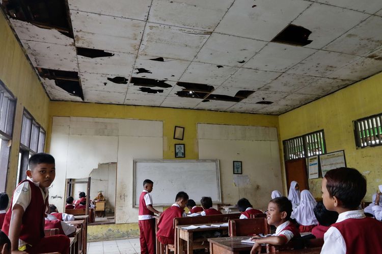 Murid SD Negeri Samudrajaya 04, Kecamatan Tarumajaya, Kabupaten Bekasi belajar di ruang kelas yang rusak, Senin (20/1/2020). Kondisi sekolah yang rusak sejak 2014 ini membuat proses belajar mengajar tidak nyaman.