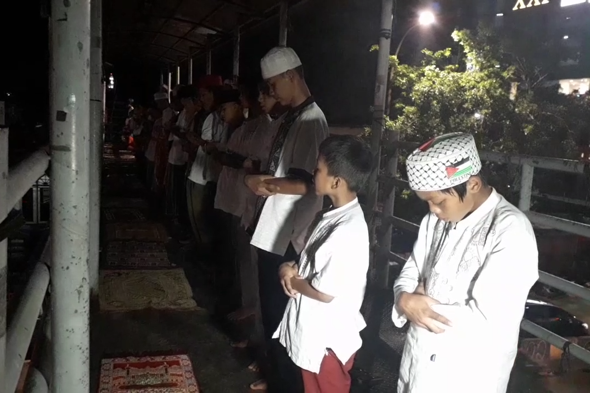 Jemaah mendirikan shalat tarawih di atas JPO Pasar Gembrong, Senin (6/5/2019).