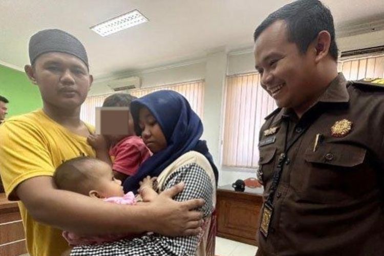Kasi Pidum Kejari Kabupaten Pasuruan, Yusuf Akbar Amin tersenyum melihat kebahagiaan M Gufron bersama anak dan istrinya setelah bebas dari tuntutan pidana setelah melalui proses restorative justice. 

