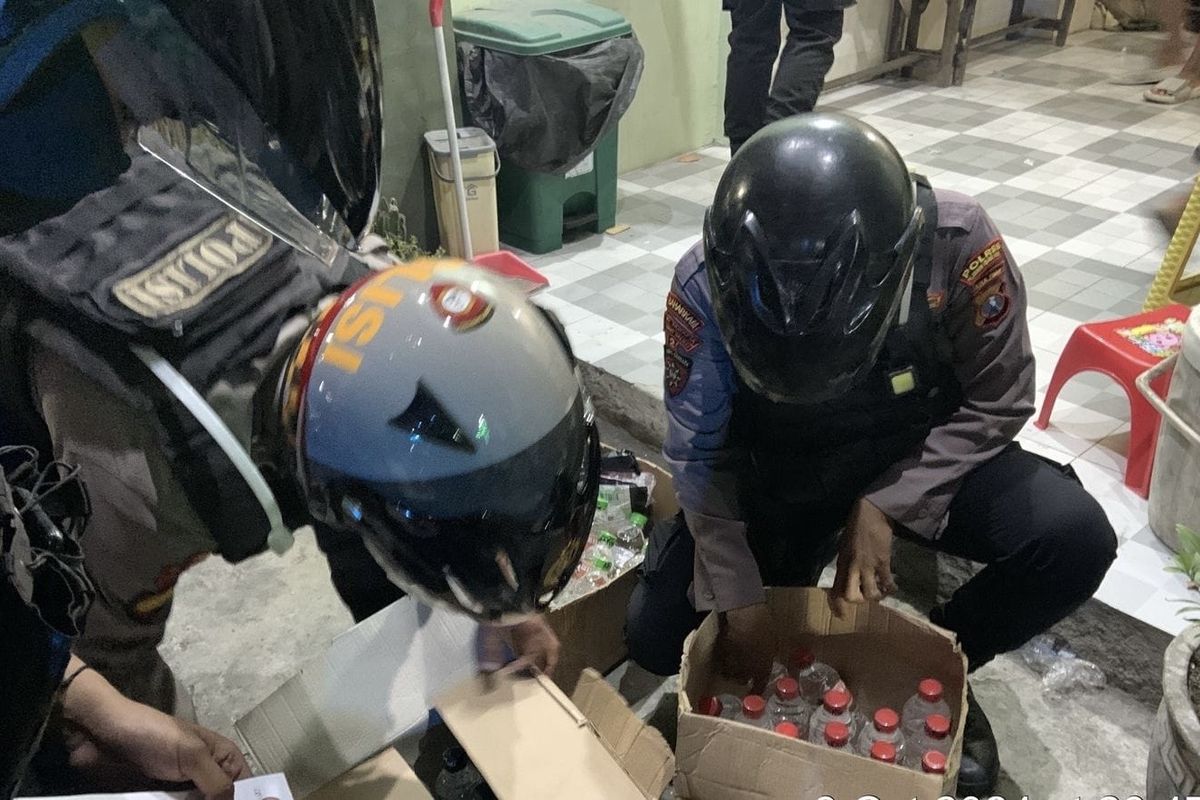 Polisi saat menyita ribuan botol miras saat gerebek toko kelontong di Surabaya, Jumat (11/10/2024).