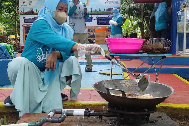 Ibu-Ibu di Manggar, Balikpapan Timur menggunakan aliran gas metana dari tumpukan sampah untuk memasak.