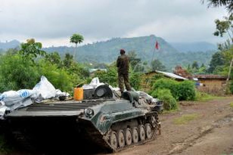 Seorang prajurit AD Republik Demokratik Kongo menatap puncak bukit Mbuzi sambil berdiri di atas sebuah tank di Rushturu, Selasa (4/11/2013), setelah berhasil merebut wilayah itu dari pemberontak M23. Setelah terus dipukul mundur dari sejumlah posisi penting, pemberontak M23 akhirnya bersedia meletakkan senjata.