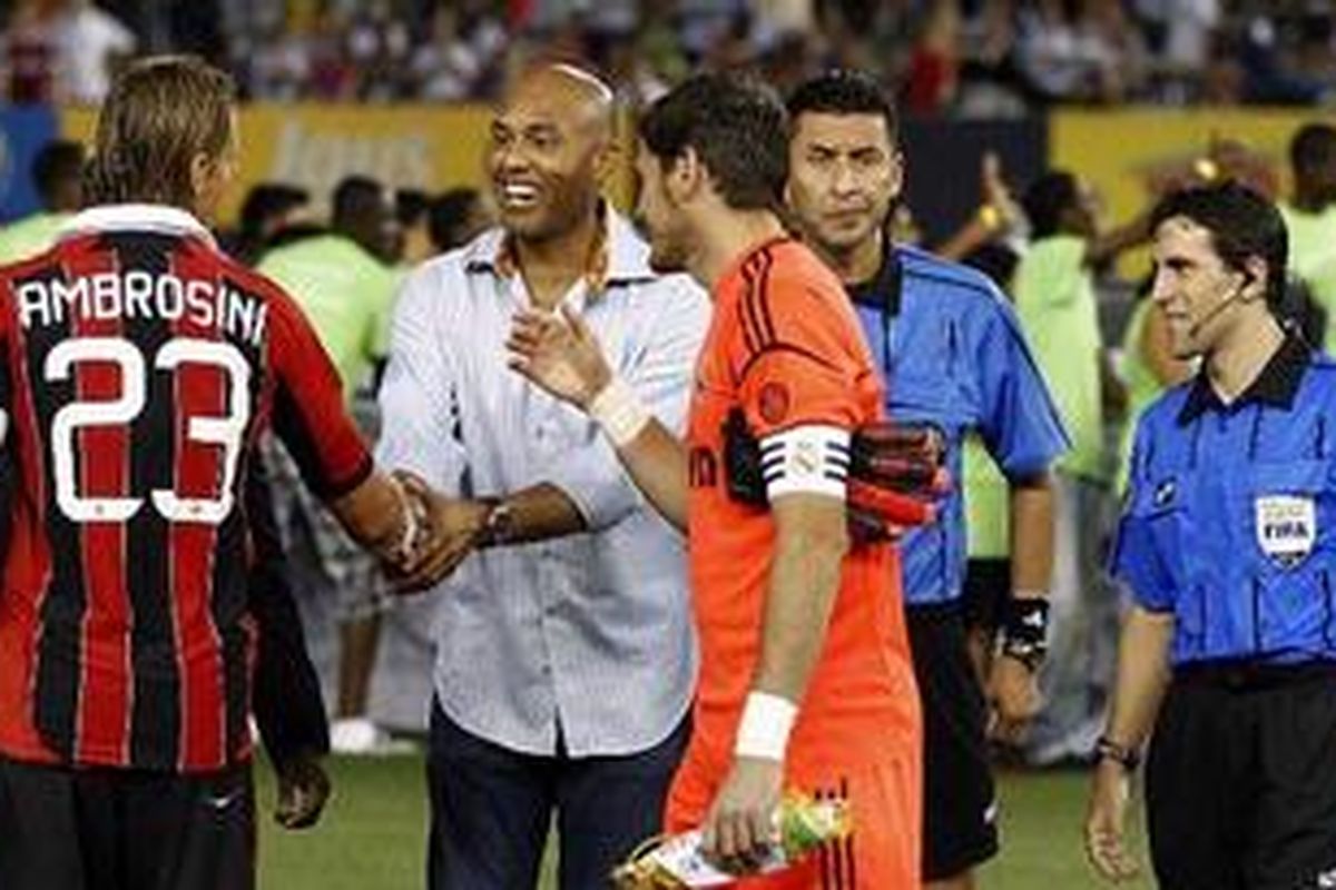 Kapten AC Milan, Massimo Ambrosini (merah-hitam) dan kiper sekaligus kapten Real Madrid, Iker Casillas (oranye), bertukar bendera tim jelang pertemuan kedua tim di Stadion Yankee, New York, 8 Agustus 2012. Pada pertandingan tersebut, Madrid menang telak 5-1 atas Milan.