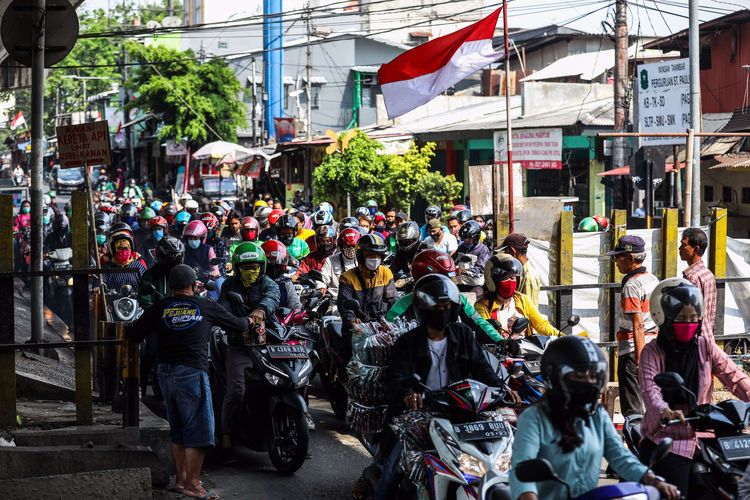 Pengguna kendaraan bermotor menggunakan masker saat melintasi rel kereta di Jalan Tanjung Selor, Grogol, Jakarta Barat, Senin (24/8/2020). Gubernur DKI Jakarta Anies Baswedan memutuskan untuk kembali memperpanjang pembatasan sosial berskala besar (PSBB) yang keempat kalinya terhitung mulai Jumat (14/8/2020) sampai 27 Agustus 2020.