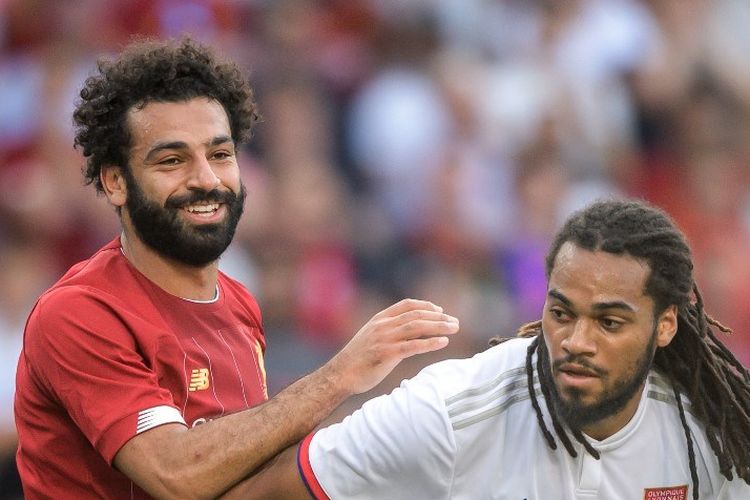 Mohamed Salah tampak tersenyum seusai berebutan bola dengan Jason Denayer pada laga Liverpool vs Lyon di Jenewa, 31 Juli 2019. 