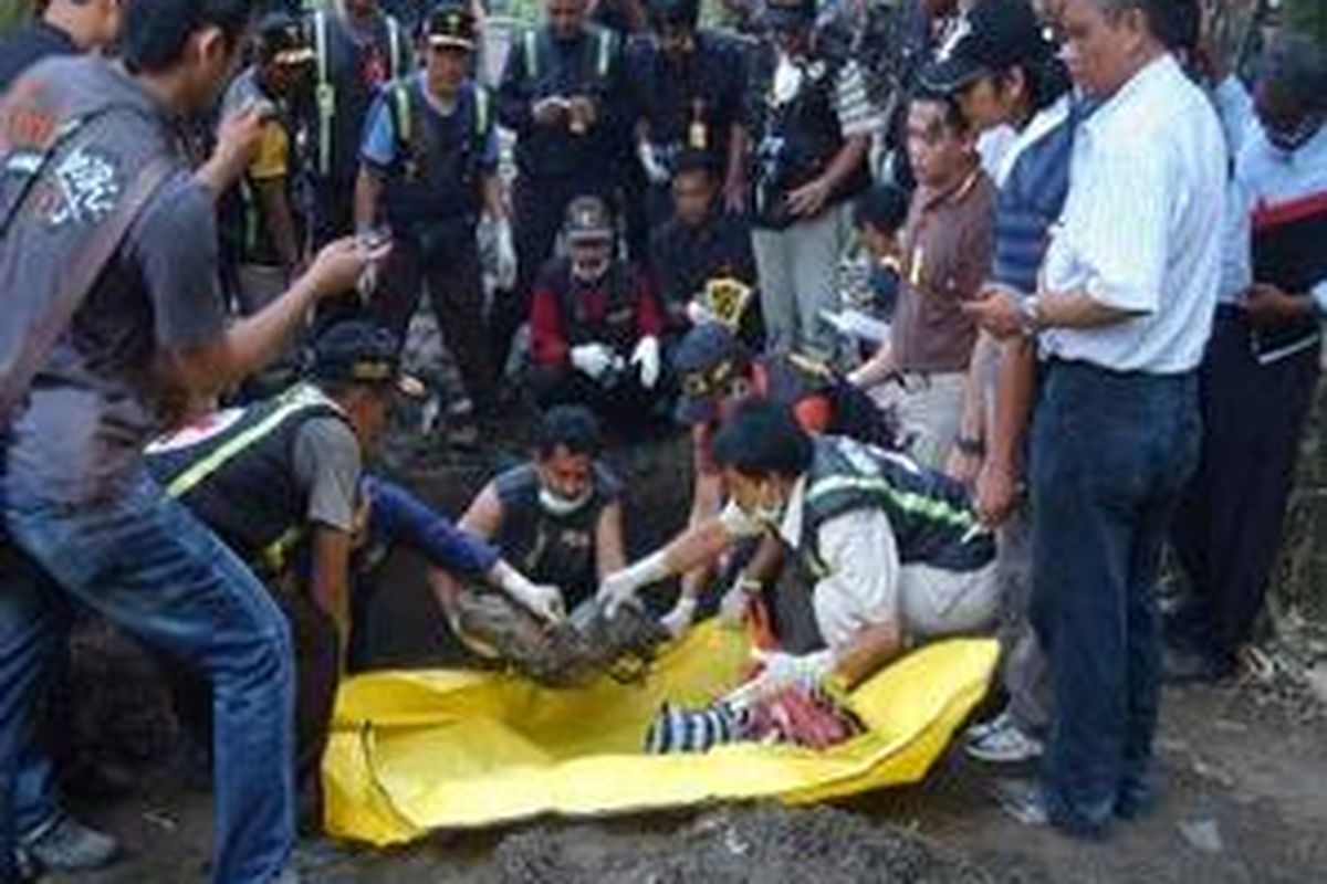 Petugas forensik dari Polda Jatim mengangkat jenazah yang baru ditemukan usai penggalian di TKP V, di Dusun Maijo, Desa Jatiwates, Kecamatan Tembeleng, Jombang, Jawa Timur, Senin (28/7). Jenazah tersebut diduga korban pembunuhan berantai dengan tersangka Ryan. 