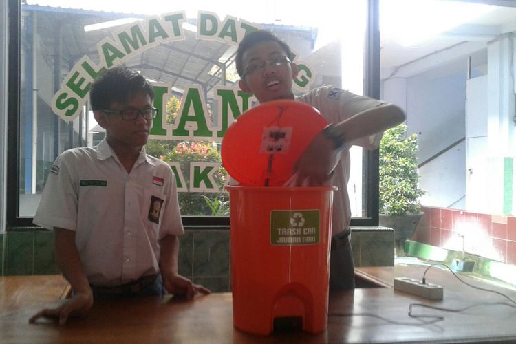 Syaifullah Yusuf Ramadhan (16) dan Fatih Abdullah (17) dua pelajar program Boarding School Madrasah Aliyah Negeri (MAN) 1 Surakarta saat memperlihatkan robot tempat sampah ciptaannya di lobi sekolah setempat, Senin (27/11/2017).