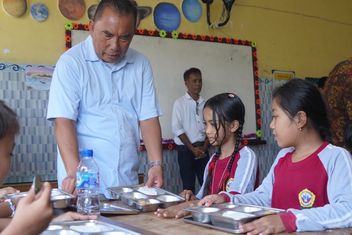 Bupati Jembrana I Nengah Tamba saat memantau pelaksanaan program makan siang gratis hari kedua di SDN 2 Pengambengan, Selasa (7/1/2025). 