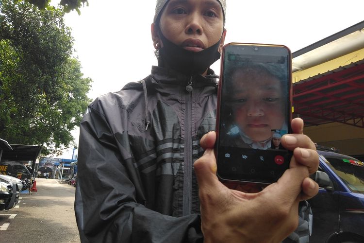 Rohendi tengah memperlihatkan hasil tangkapan layar video call terakhir saat anaknya yang nangis ingin pulang, di Mapolrestabes Bandung, Jumat (1/10/2021).