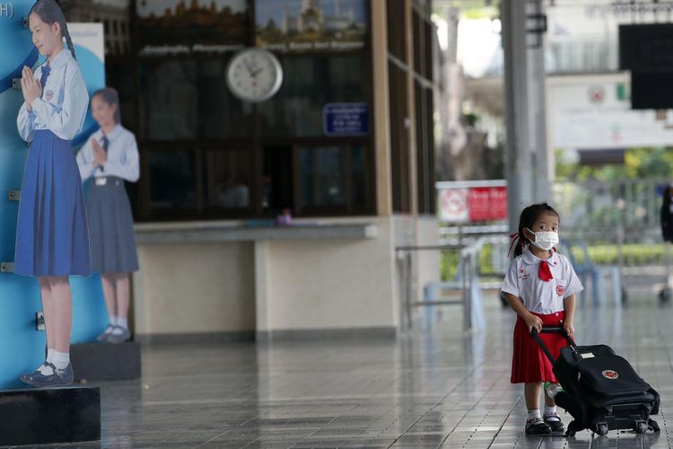 Seorang siswa Thailand yang mengenakan topeng pelindung menunggu orang tuanya untuk dibawa pulang setelah seorang siswa dinyatakan positif COVID-19, di sebuah sekolah di Bangkok, Thailand, 26 Februari 2020 EPA-EFE/RUNGROJ YONGRIT