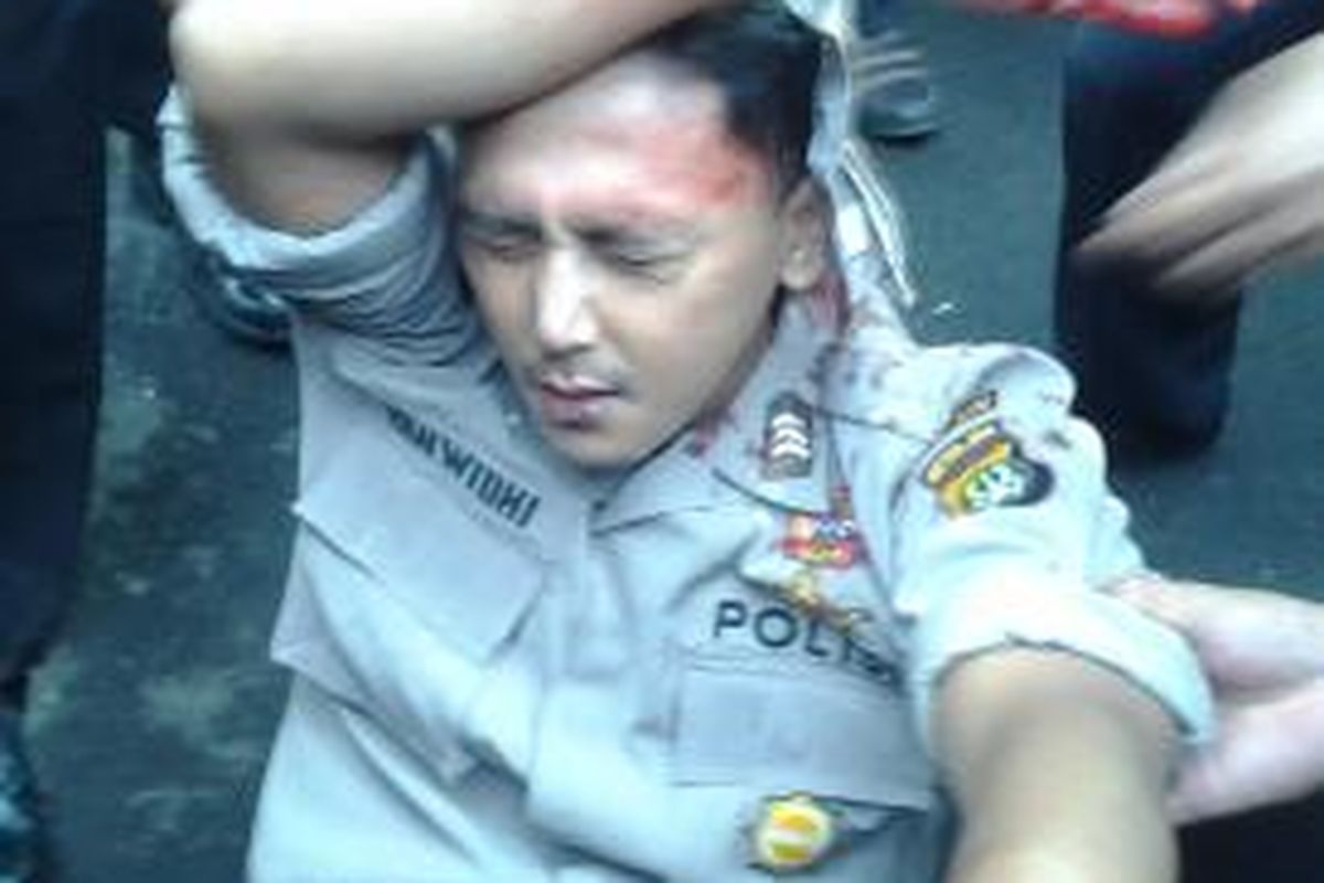 Brigadir Yan Widhi usai tertembak rekannya sendiri, Brigadir Gusti dalam aksi unjuk rasa di depan KPUD Kota Tangerang, Kamis (25/7/2013)