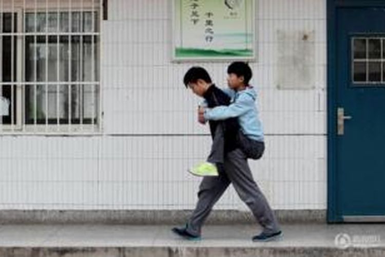 Xie Xu (18) selama tiga tahun menggendong Zhang Chi (19) kawan sekelasnya yang menderita kelumpuhan agar tak ketinggalan pelajaran di sekolah. Aksi mulia pelajar ini mendapat banyak dukungan warga China.