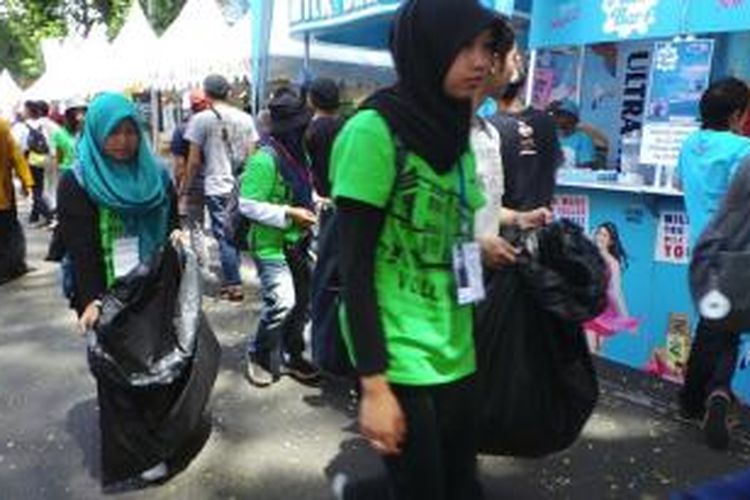 Para volunter Karnaval Asia Afrika dengan bertugas menjaga kebersihan acara dengan memungut sampah di Jalan Ir. H. Djuanda, Bandung, Jawa Barat, Minggu (26/4/2015). Konsep voluntourism di acara Karnaval Asia Afrika dianggap Wali Kota Bandung, Ridwan Kamil berhasil mendukung keberhasilan acara.