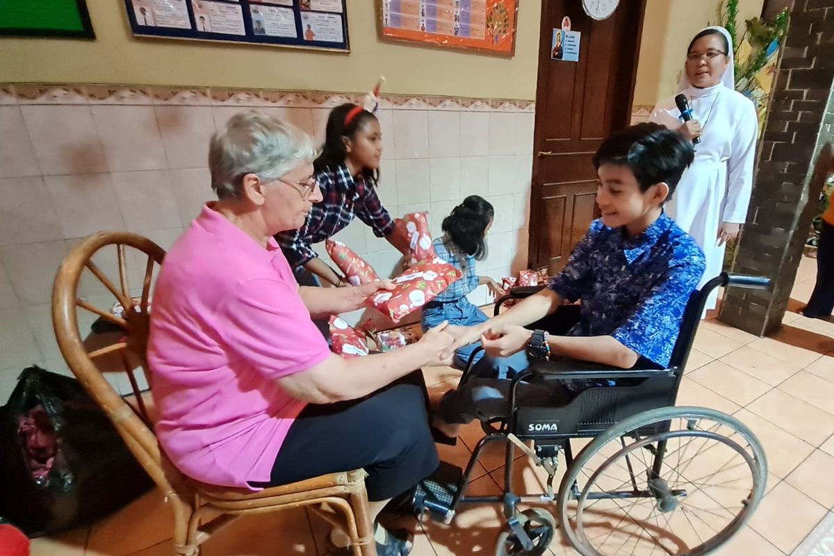 Pendiri Yayasan Sinar Pelangi (YSP), Sr. Andre Lemmers FCJM memberikan hadiah Natal kepada setiap orang pada acara Natal, Senin (26/12/2022)