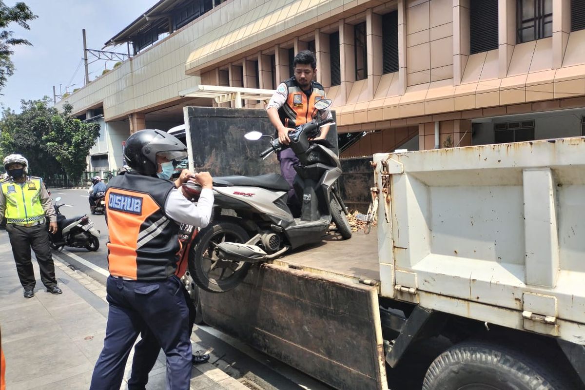 Petugas Suku Dinas Perhubungan Jakarta Pusat terlihat sedang menindak kendaraan pelanggar parkir liar di Cikini, Gambir, Jakarta Pusat, Rabu (18/5/2022).