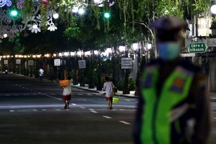 Polisi dikerahkan untuk membantu warga menerapkan penjarakan sosial di Surabaya, Jawa Timur. 