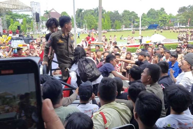 Petugas keamanan dan Satpol-PP membawa dua copet yang diamankan di acara Kirab Bendera Merah Putih di Jalan Tegar Beriman, Cibinong, Kabupaten Bogor, Jawa Barat, Kamis (14/8/2025).