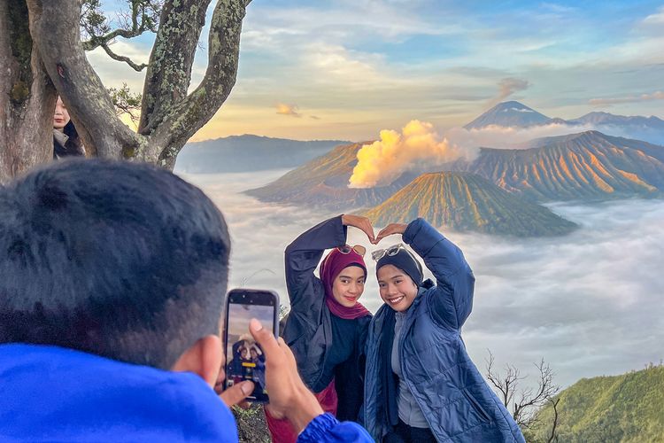 Wisatawan Berfoto dengan Latar Belakang Lautan Awan Kaldera Bromo di Bukit Kingkong.