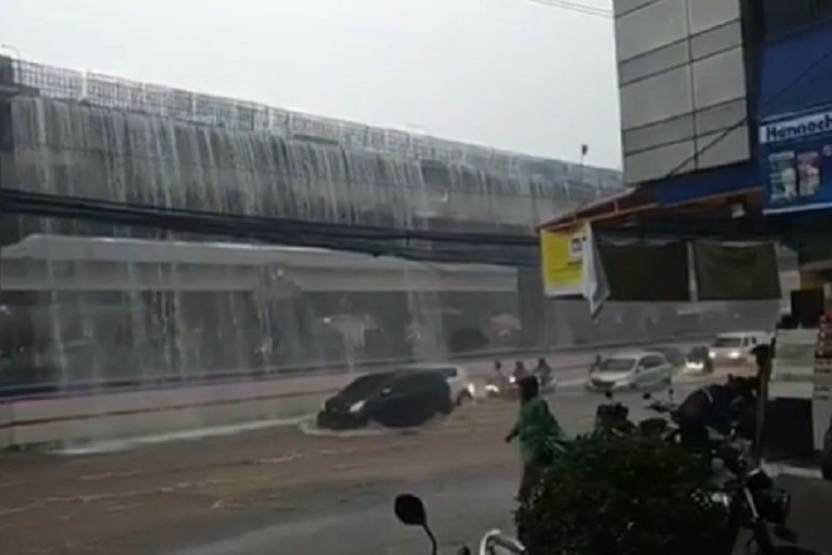 Limpas air turun dari Jalan Tol Becakayu di dekat Kota Bintang, Bekasi, saat hujan deras mengguyur kawasan itu, Kamis (21/11/2019) kemarin.