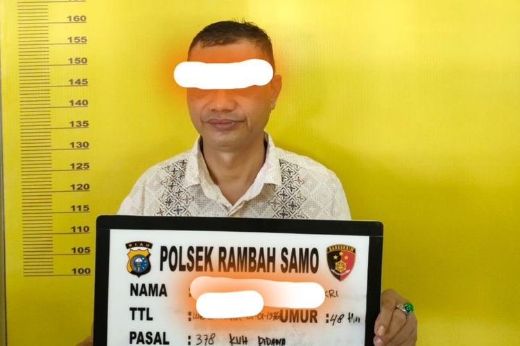 Kepala Desa Teluk Aur, SH saat diamankan di Polsek Rambah Samo di Kabupaten Rokan Hulu, Riau, Rabu (30/3/2022).
