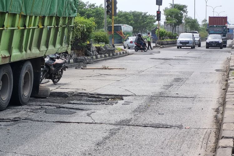 Jalan rusak di ruas jalan nasional yang berlokasi di Jalan Kaligawe Raya Semarang pasca terkena banjir, Kamis (5/1/2023).