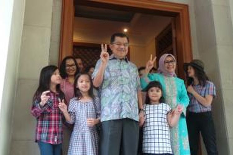 Calon wakil presiden Jusuf Kalla dan istrinya, Mufidah Kalla memberikan salam dua jari sebelum menggunakan hak pilihnya di tempat pemungutan suara (TPS) 03, Kelurahan Pulo, Jalan Brawijaya, Jakarta Selatan, Rabu (9/7/2014).