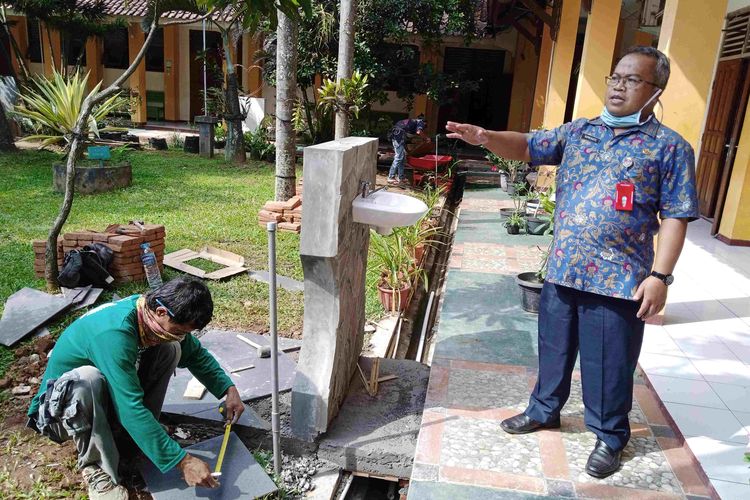 Kepsek SMAN 1 Ungaran Supriyanto menunjukkan pembangunan tempat cuci tangan. 