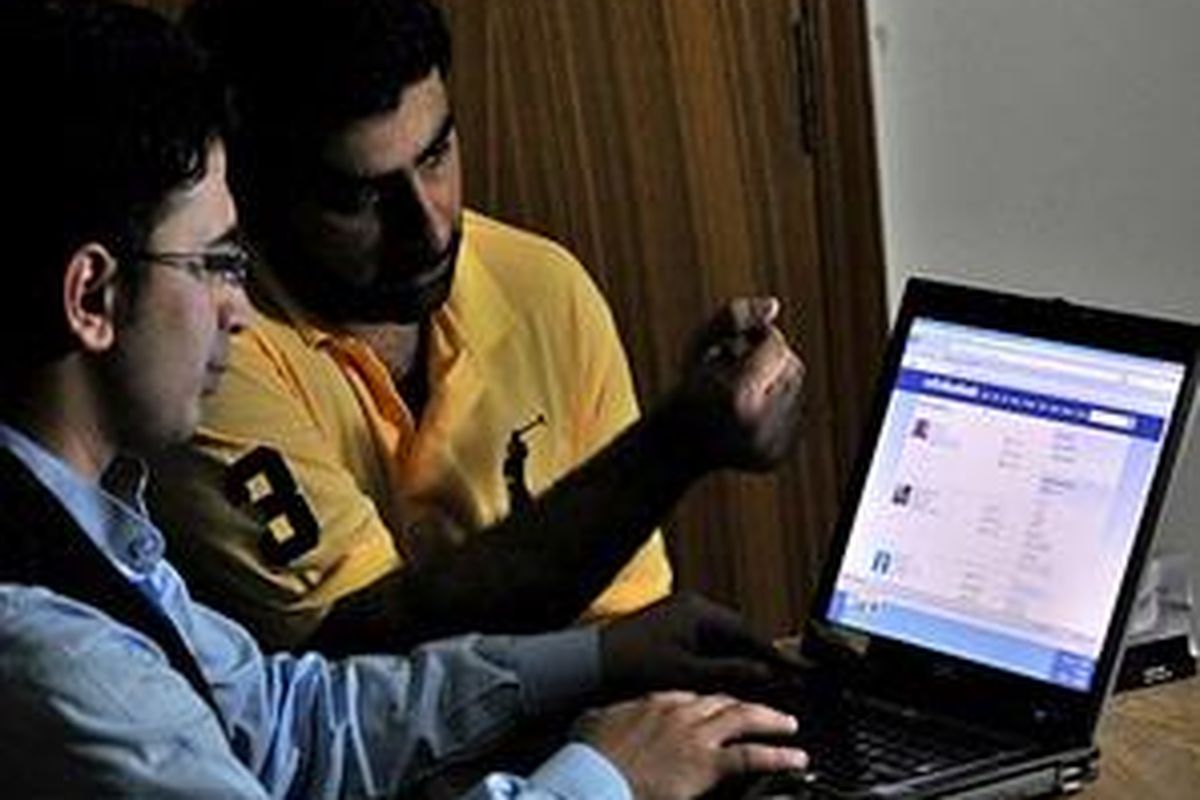 Pakistani IT professionals Omer Zaheerand Arslan Chaudhry browse their newly created networking site in Lahore  