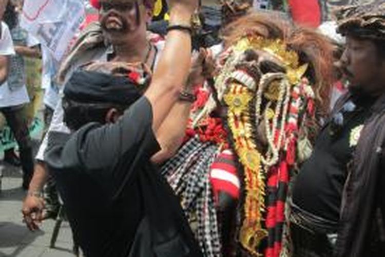 Pengunjuk rasa sedang menusukkan keris ke dada barong dalam aksi unjuk rasa menolak reklamasi Teluk Benoa di Bali, Sabtu (15/11/2014).