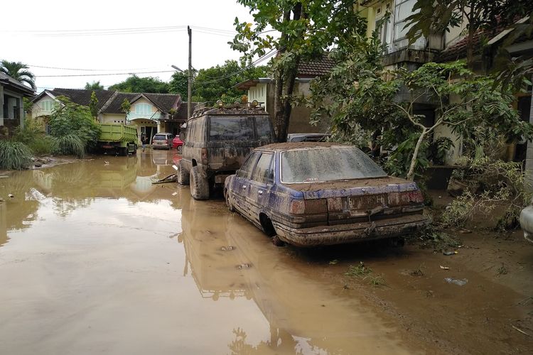 Seseorabg berjalan di tengah banjir dan lumpur di perumahan De Flamboyan di Kelurahan Tanjung Selamat, Kecamatan Medan Tuntungan pada Kamis malam hingga Jumat dini hari (4/12/2020).